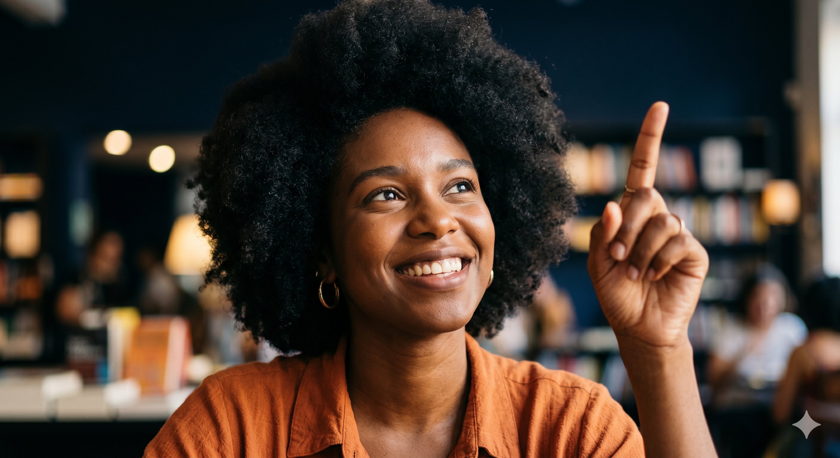 Agente cultural — mulher negra sorrindo e apontando para cima